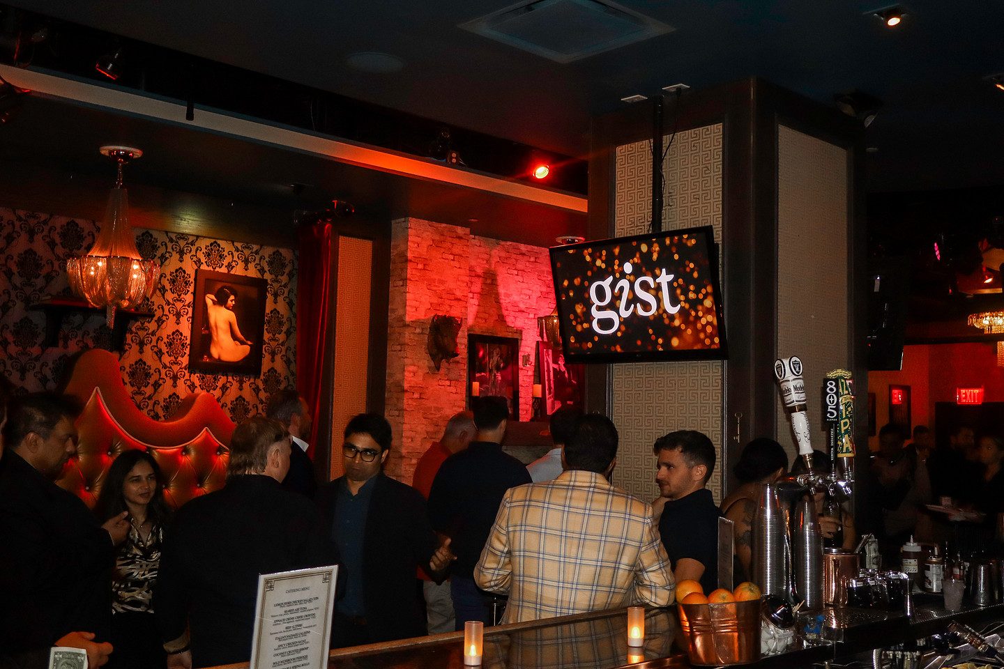 Guests gathered in the warmly lit bar room during the soirée
