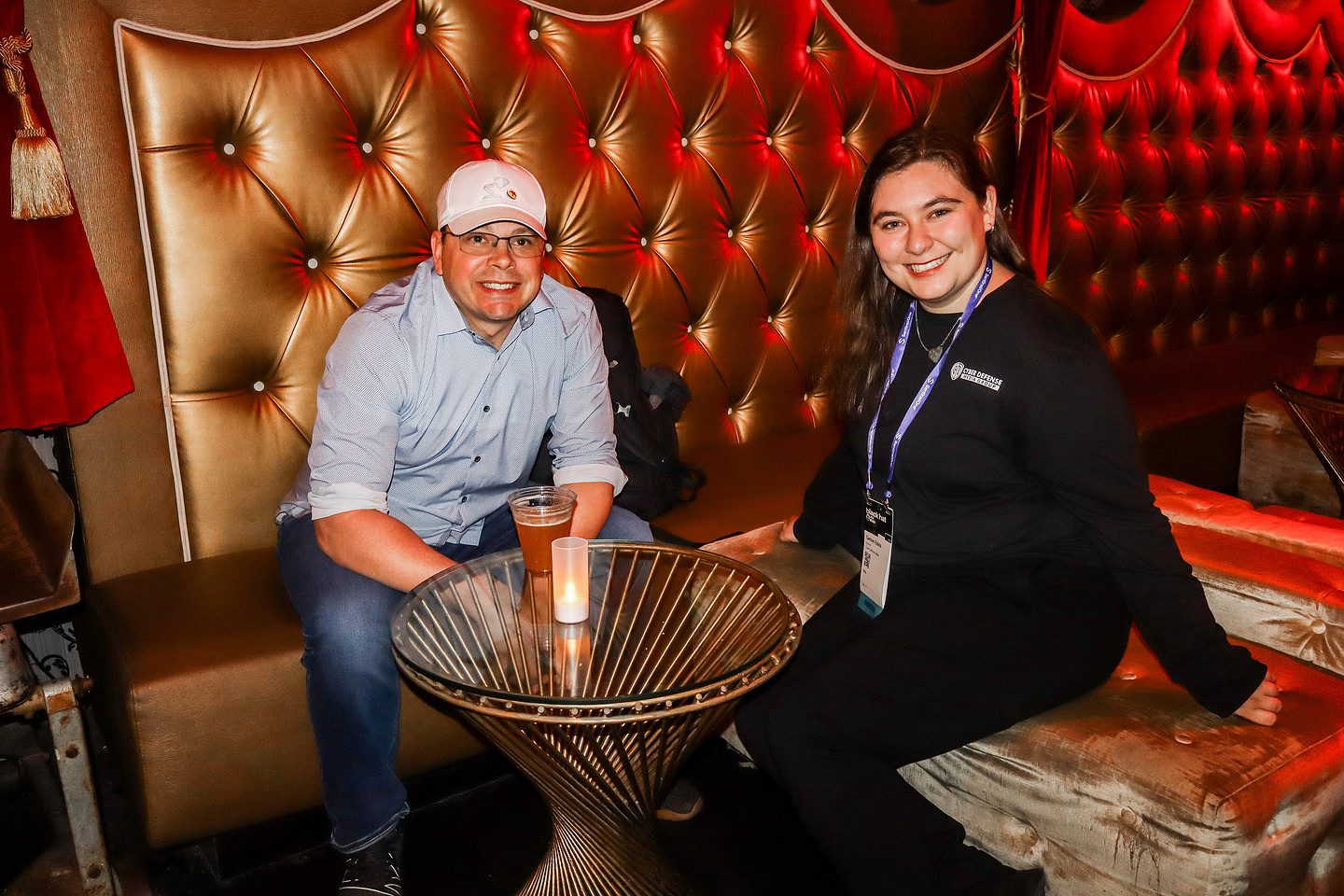 Two guests seated together in a red velvet booth