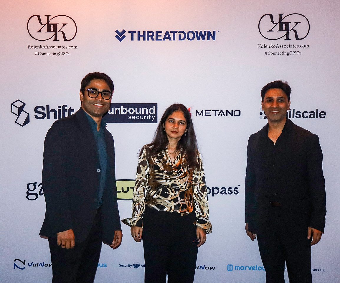 Three guests photographed together at the sponsor backdrop