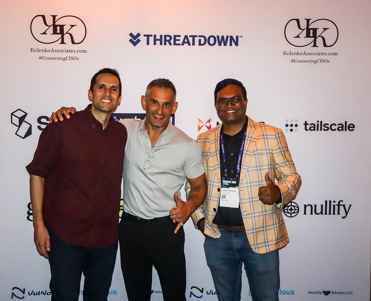 Three guests photographed together at the sponsor backdrop